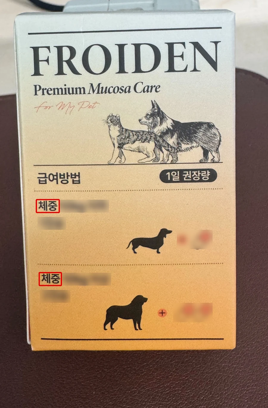 사용자 제공 실물 뮤코사케어 상자 한 면, 급여방법 칸의 체중 두 곳에 빨간 박스, 체중 숫자와 캡슐 수·캡슐 그림은 흐림