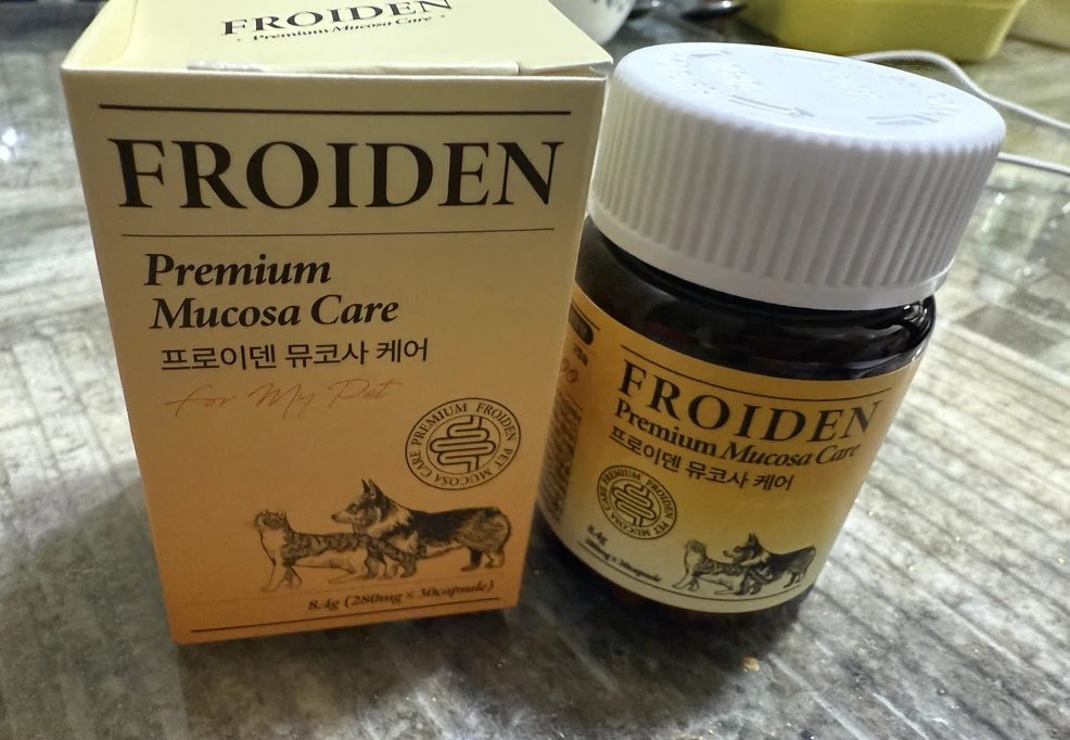 대리석 무늬 식탁 위에 놓인 뮤코사케어 노란 상자와 갈색 통